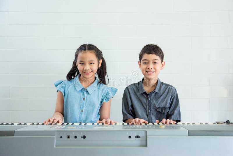 Children playing music keyboard at music school stock photo Children playing music keyboard at music school stock photo