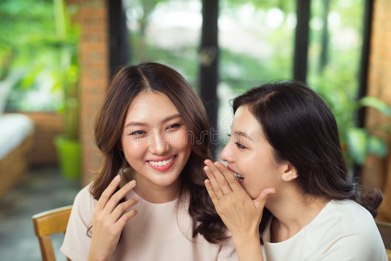 two-asian-women-friends-chatting-gossipping-99609011.jpg