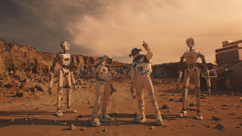 Two astronauts stand on Mars surface with robots royalty free stock photo