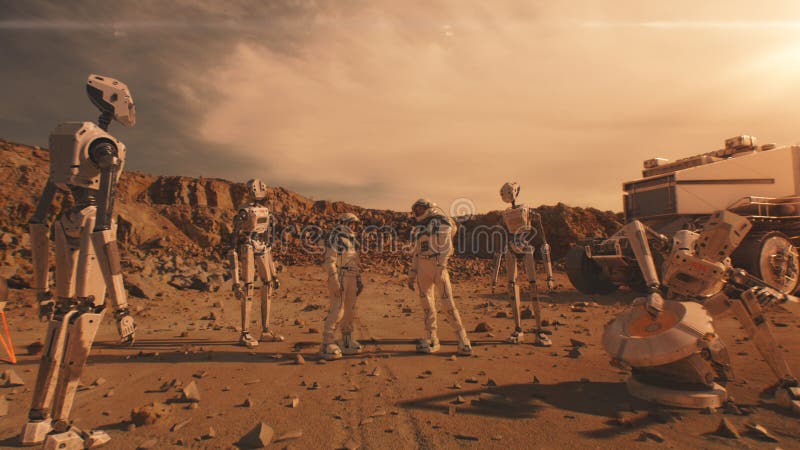 Two astronauts stand on Mars surface with robots stock photo