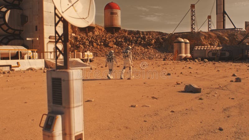 Two astronauts walk on Mars surface on research station royalty free stock photo