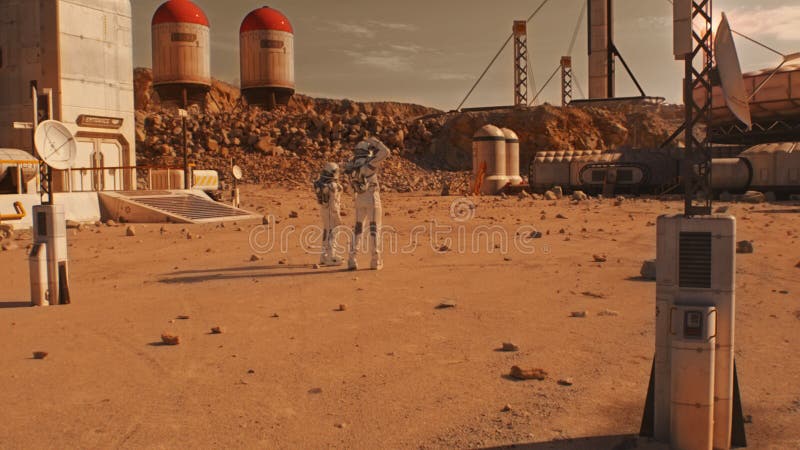Two astronauts walk on Mars surface on research station royalty free stock photos