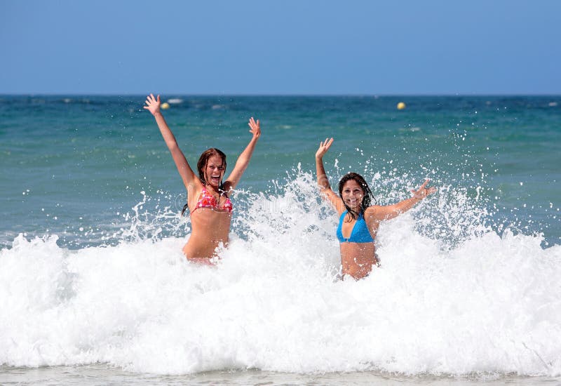 Due belle giovani amiche giocando in mare dalla spiaggia, in vacanza o in vacanza al sole.