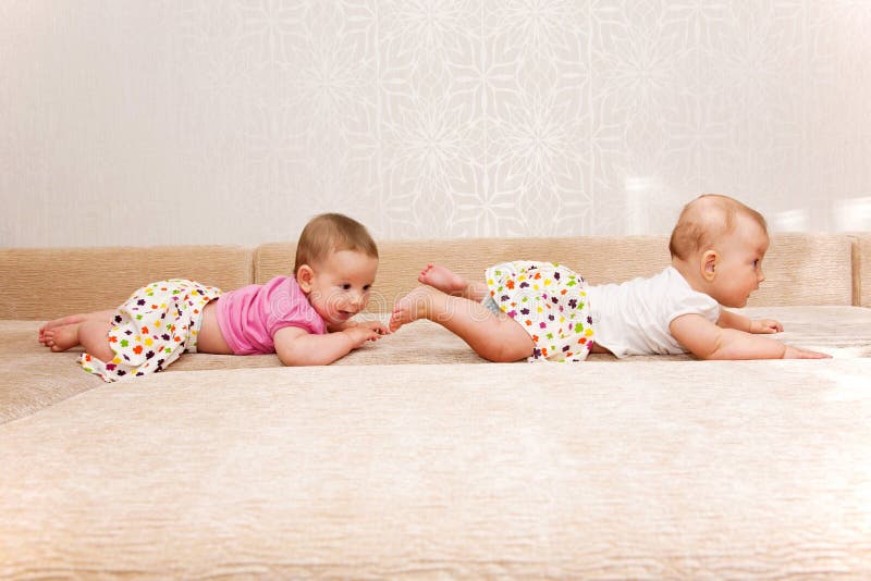 Two baby twins crawling one after another