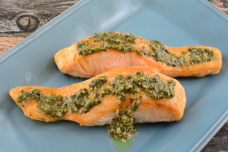 Baked salmon fish fillets with pesto sauce