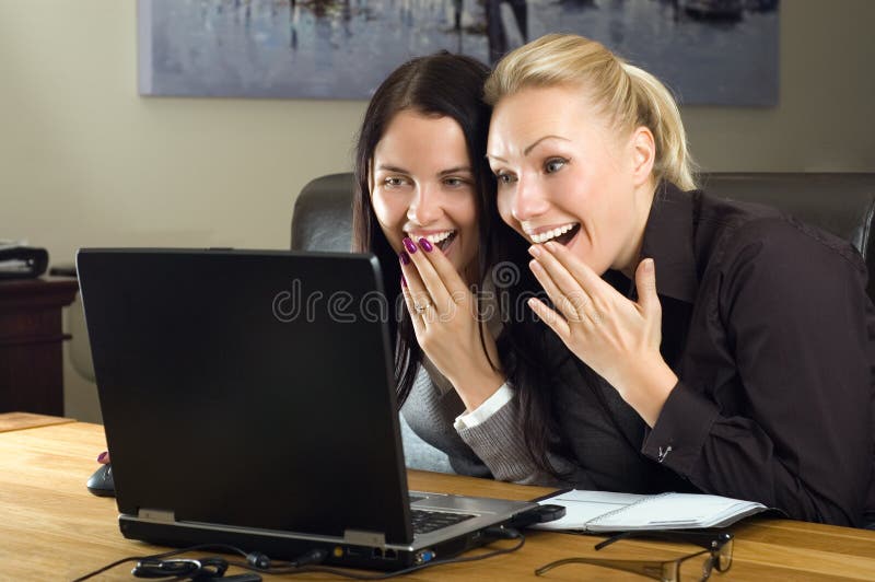 Two beautiful girls with laptop in the office