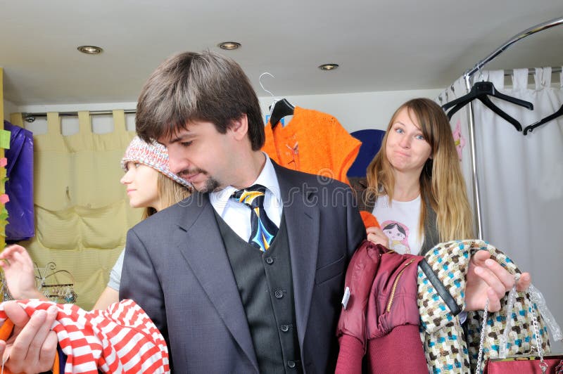 Two beautiful girls shop with a man