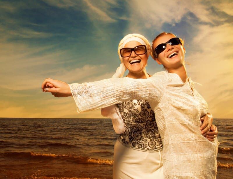 Two beautiful women relaxing near the ocean