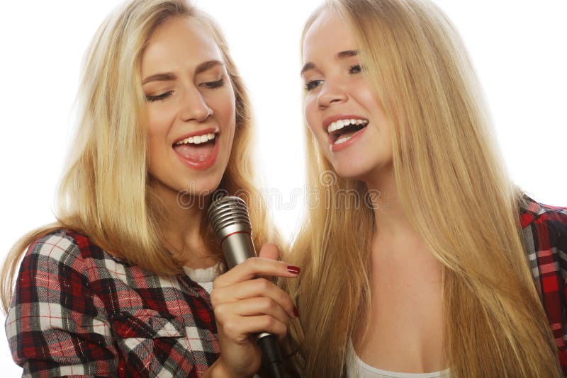 Two Beauty Girls With A Microphone Singing And Having Fun Stock Image