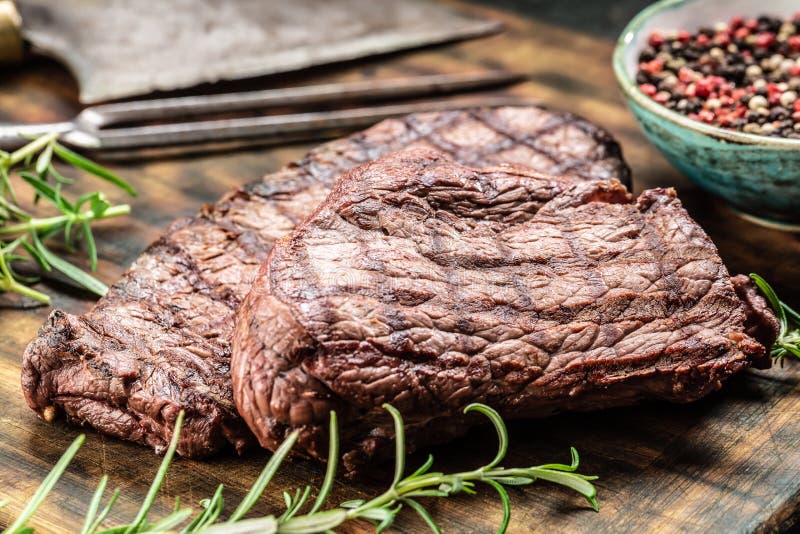 Two Beef Rump Steaks with Herbs Tomatoes Salt and Spices on Butcher