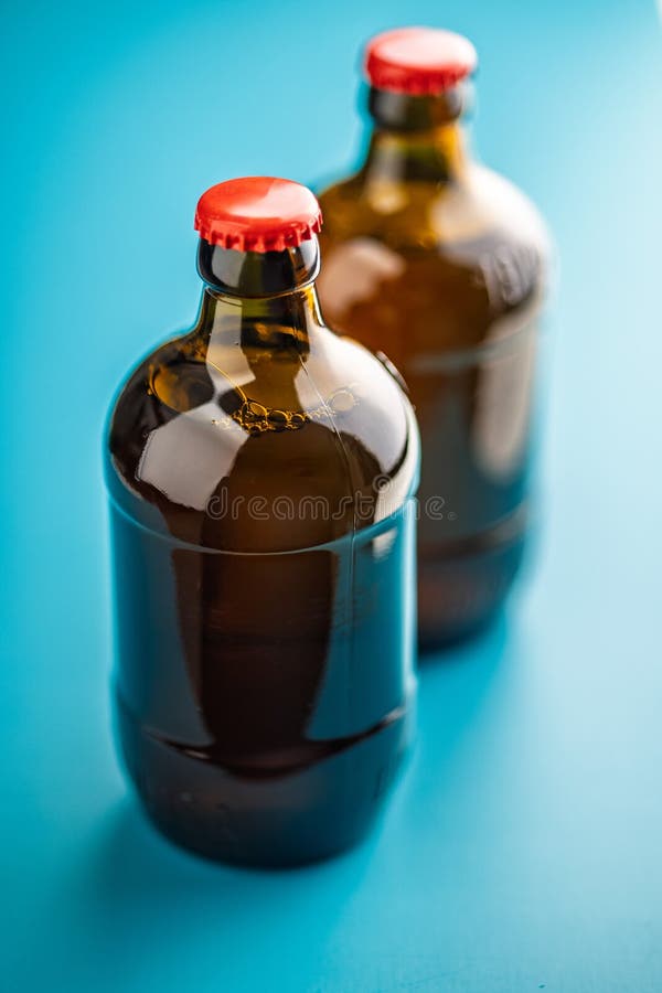 Two beer bottles on blue background stock photo
