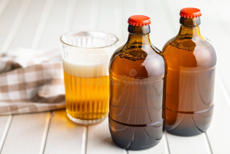 Two beer bottles on white table stock photos