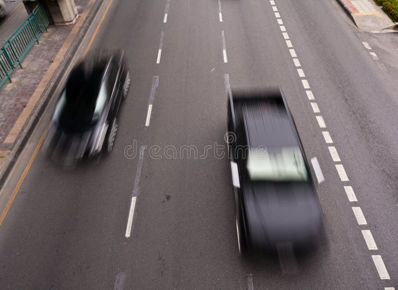 Two black cars running on the road