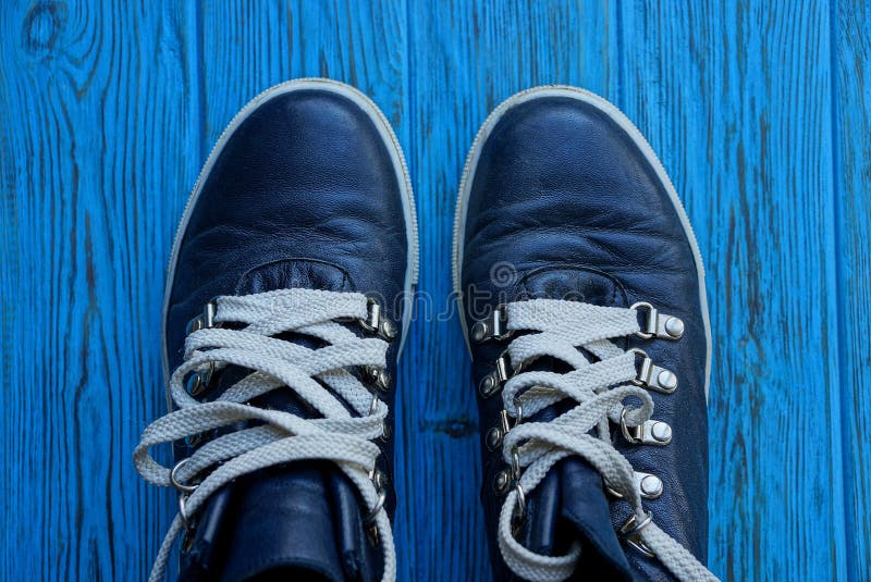 Two Black Shoes with White Laces on a Blue Board Stock Image - Image of ...