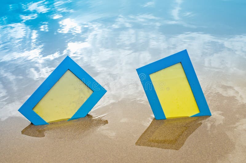 Two blue blank photo frames on the sand beach stock images