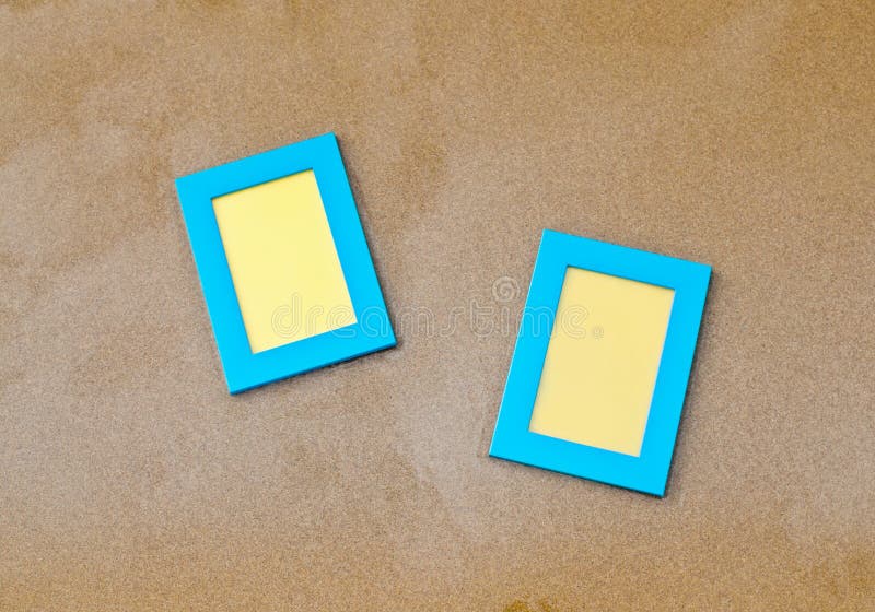 Two blue blank photo frames on the sand stock photo