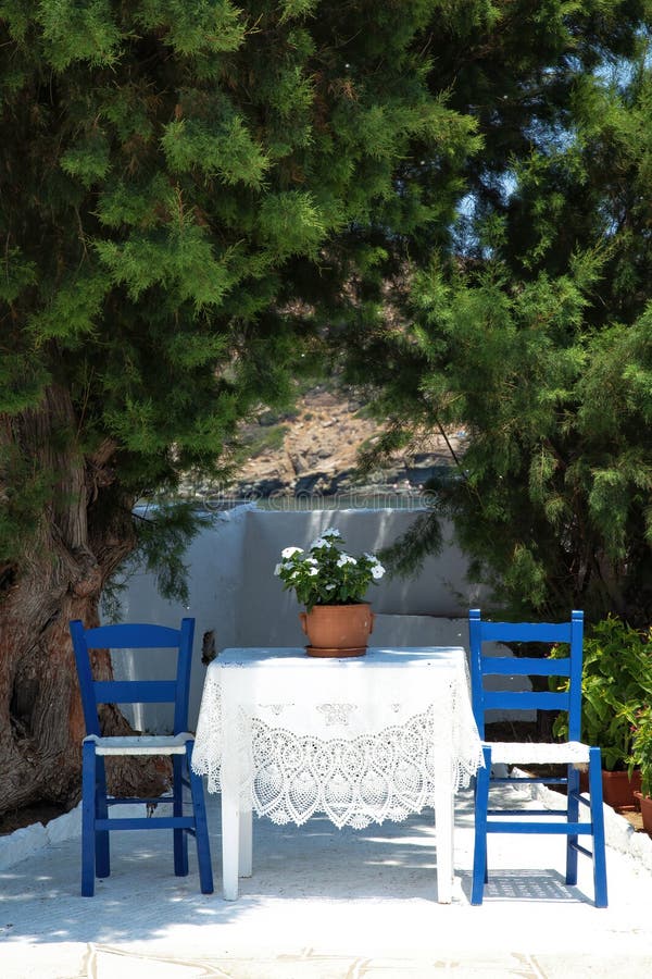 Table And Rural Chairs In Greek Outdoor Restaurant With Turquoise