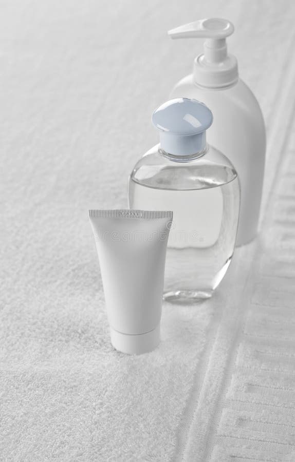 Two bottles and tube on white towel