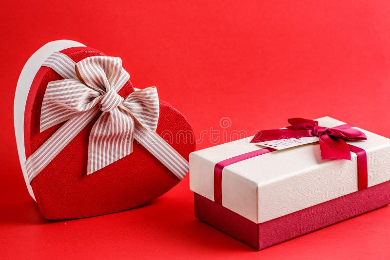 Two boxes of gifts with a ribbon on a red background. The concept is suitable for love stories, birthdays and Valentine`s Day. stock photo Two boxes of gifts with a ribbon on a red background. The concept is suitable for love stories, birthdays and Valentine`s Day. stock photo