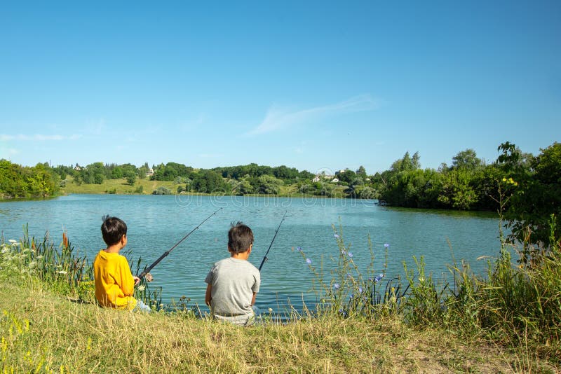 Two Boys with Fishing Rods Catch Fish on the Pond with a Grandfather Stock  Photo - Image of kids, boys: 153412746