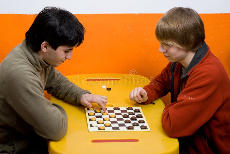 Two boys play checkers