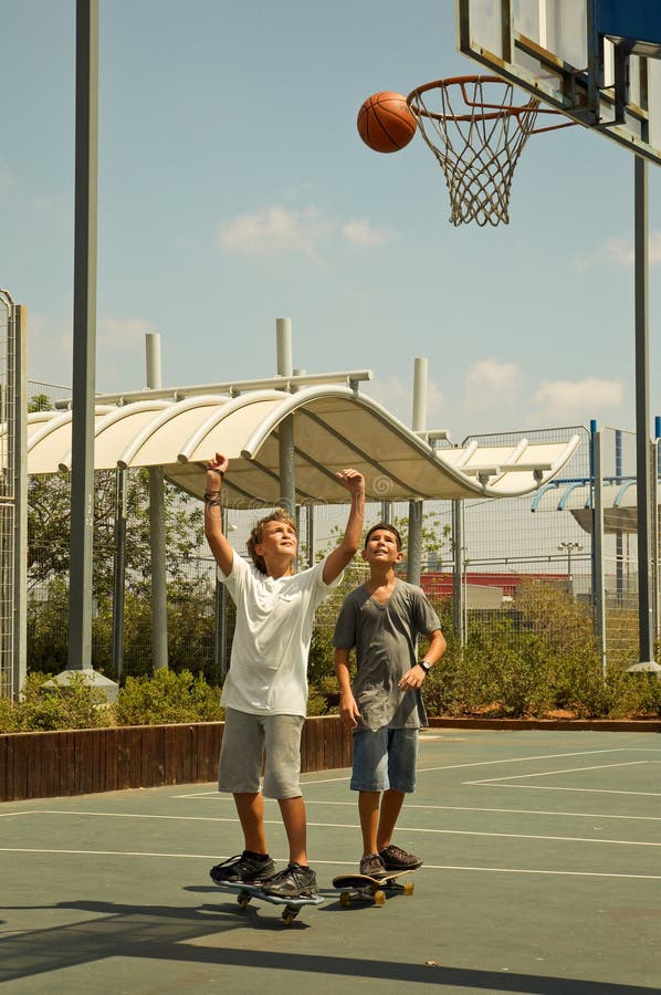 Two boys playing basketball .