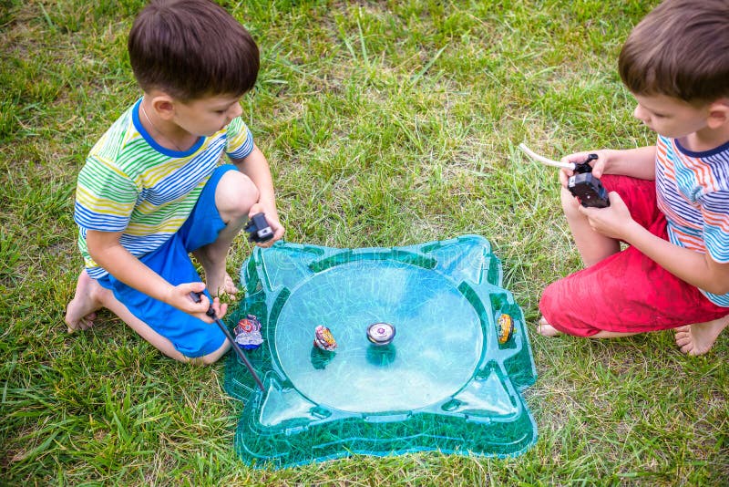 Two Boys Playing with a Beyblade, Spinning Top Kid Toy. Popular Children Game Tournament. Stock Image - Image of cartoon, play: 122435355 Two Boys Playing with a Beyblade, Spinning Top Kid Toy. Popular Children Game Tournament. Stock Image - Image of cartoon, play: 122435355