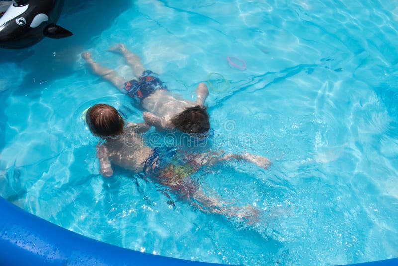 Two Boys Swimming Underwater In Backyard Swimming Pool Stock Photo