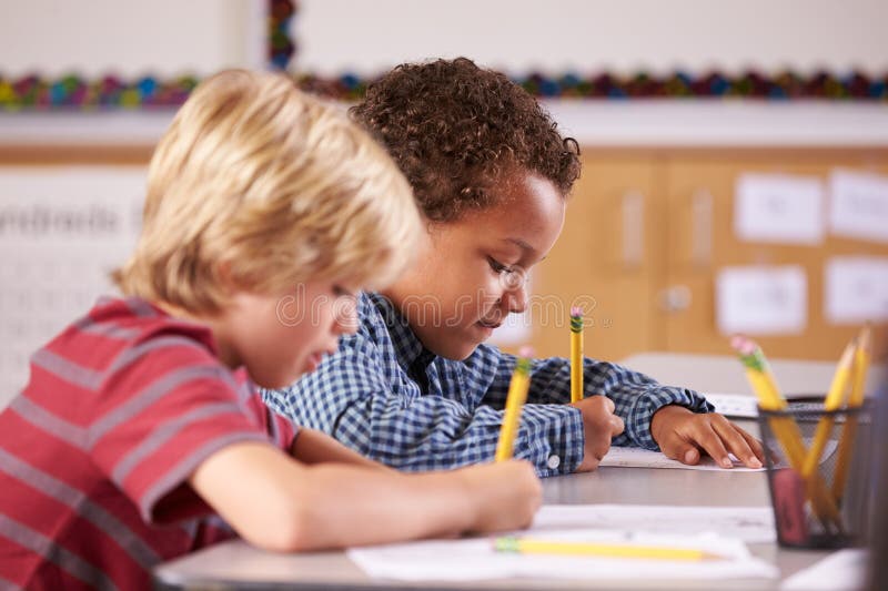Two Boys Working at Their Desks in Elementary School Class Stock Image