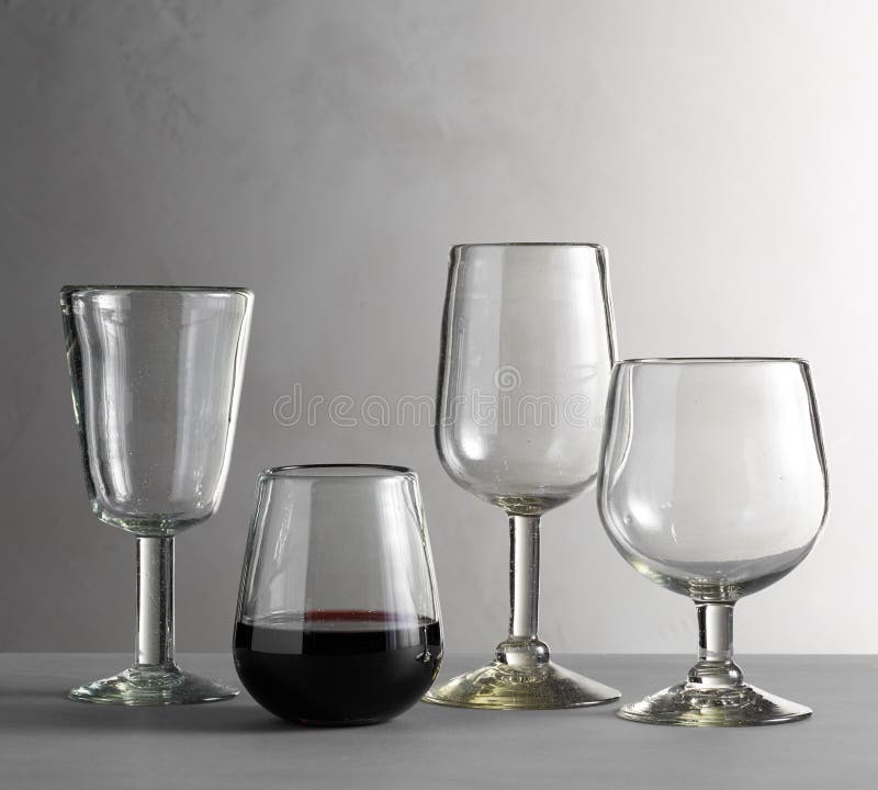 Two Brandy Glasses Empty and with Alcohol Isolated on Grey Background