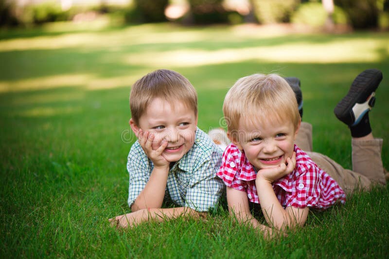 Two Brothers Lying on the Grass in a Park Outdoors, Smiling and Stock ...