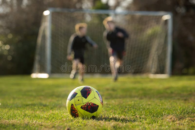 Two brothers race for a ball at the park stock photos Two brothers race for a ball at the park stock photos