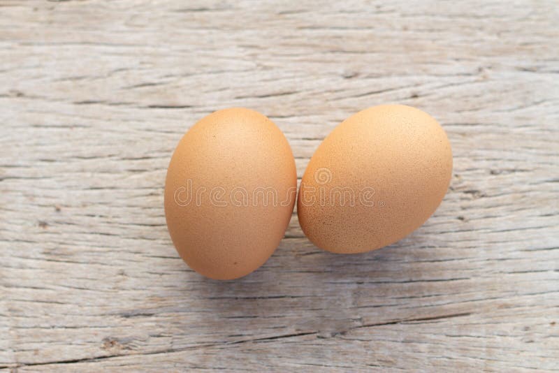 Two brown raw chickens eggs on a wooden background table royalty free stock photography
