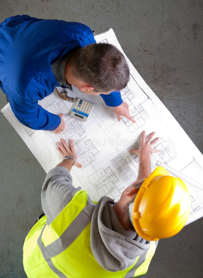 Two builders discuss construction blueprints royalty free stock photos Two builders discuss construction blueprints royalty free stock photos