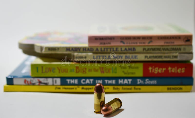 Two bullets in front of a stack of well known children`s books