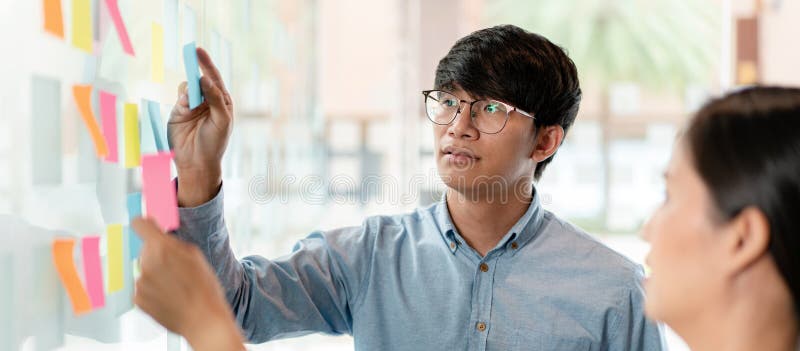 Two business executive team holding and taking notes keyword on board wall to brainstorm about a new business project for planning stock photography