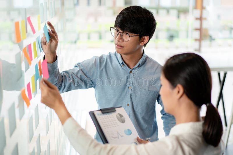 Two business executive team holding and taking notes keyword on board wall to brainstorm about a new business project for planning royalty free stock photos