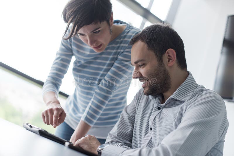 Two Business People Working With Tablet in startup office