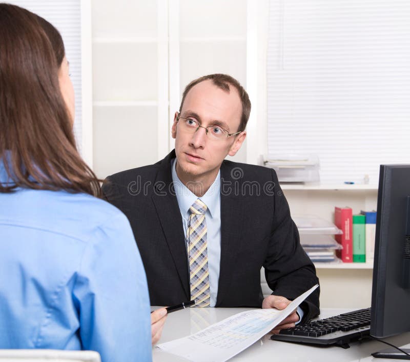 Two business people talking together at desk - adviser and customer royalty free stock photo
