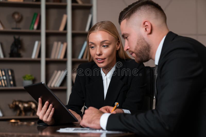 Two business people working together with tablet and taking notes royalty free stock photo