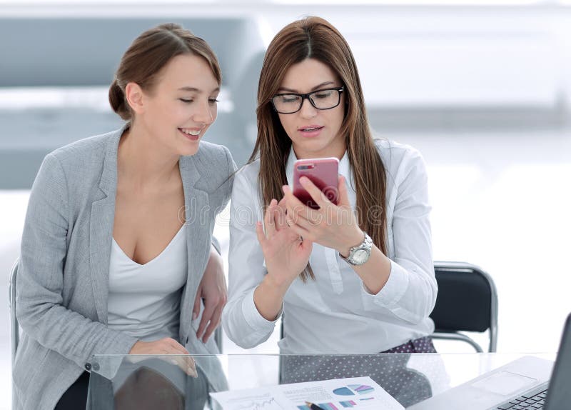 Two business women looking at the smartphone screen