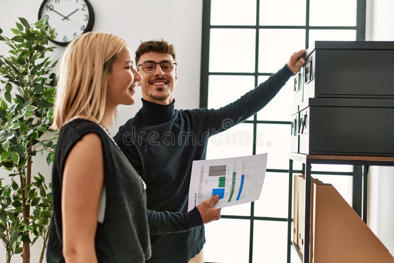 Two Business Workers Smiling Happy Saving Document on File at