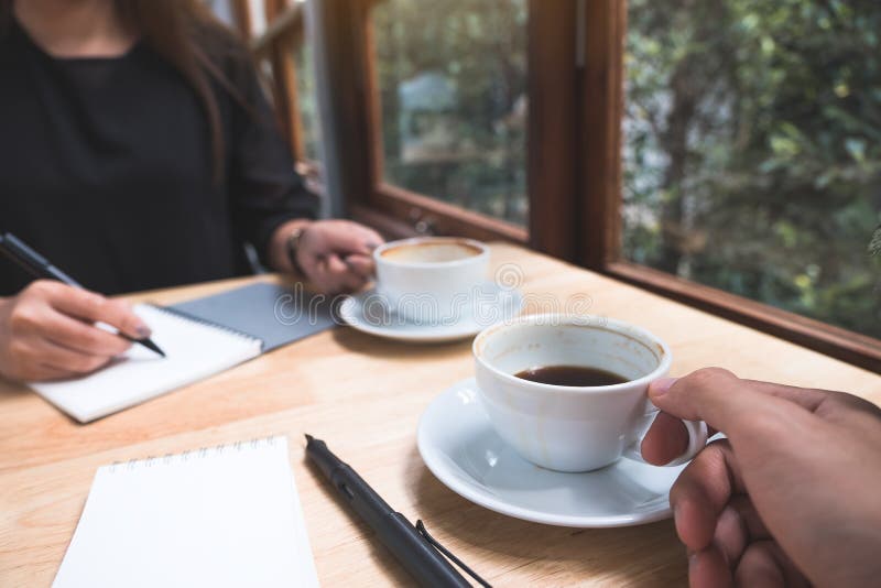 Two Businessman Drinking Coffee while Talking and Meeting in Office