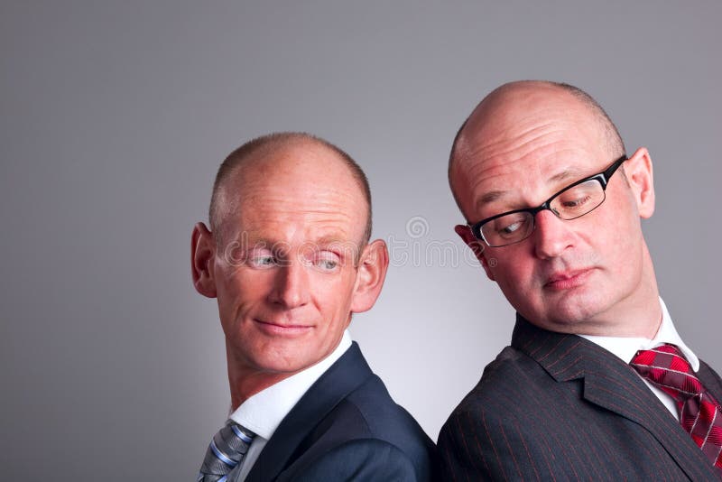 Two businessmen looking over shoulder stock photo