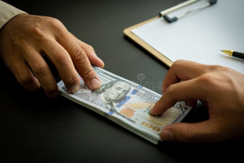 Two businessmen send money to each other to make a deal through cash and investment meetings. With charts and statistics on the tables sat opposite each other. The concept of corruption and bribery .