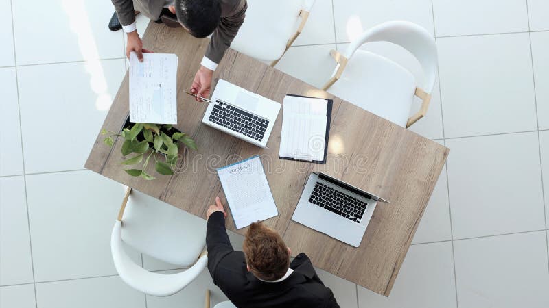Two successful smiling businessmen are working on a laptop. view from above stock images