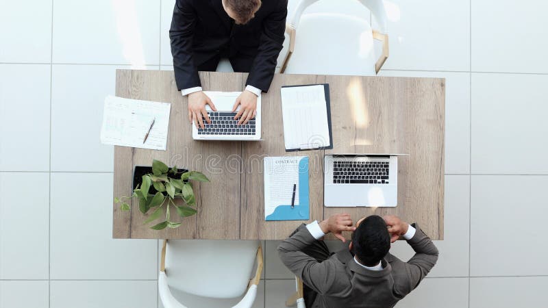 Two successful smiling businessmen are working on a laptop. view from above royalty free stock images