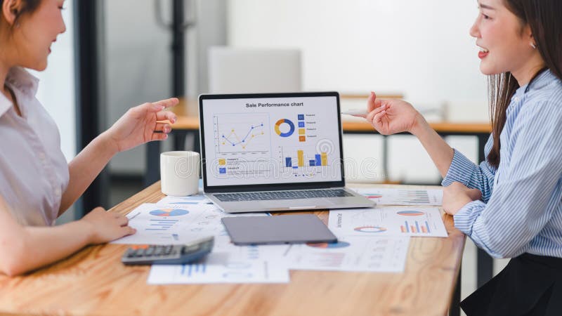 Two businesspeople or an accountant team are analyzing data charts, graphs, and a dashboard on a laptop screen in order royalty free stock photography