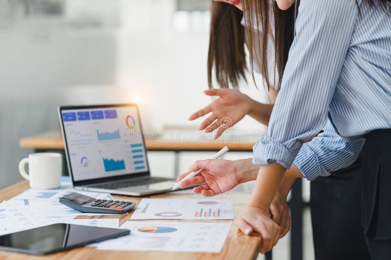 Two businesspeople or an accountant team are analyzing data charts, graphs, and a dashboard on a laptop screen in order stock photos
