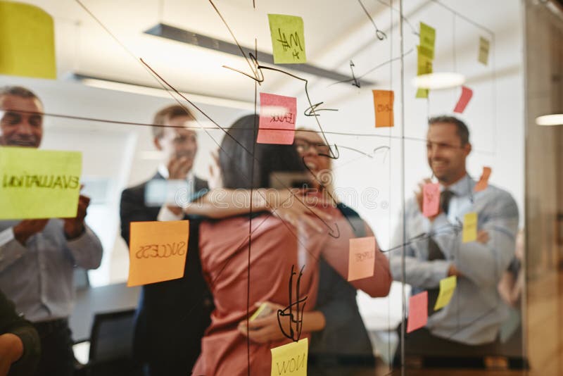 Two businesswomen hugging during an office brainstorming session royalty free stock photos Two businesswomen hugging during an office brainstorming session royalty free stock photos